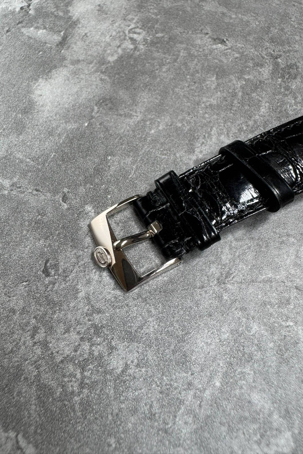 Close-up of original Concord 18K white gold buckle paired with factory alligator strap