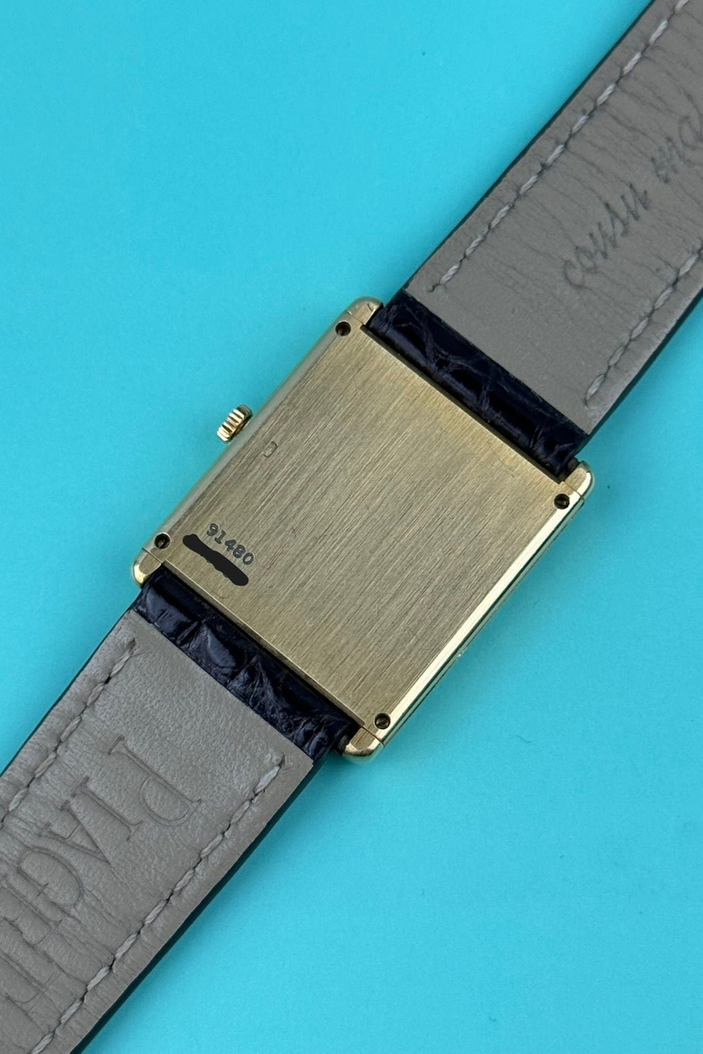 Case back of Piaget 91480 tank watch in solid yellow gold with rectangular silhouette and smooth finish