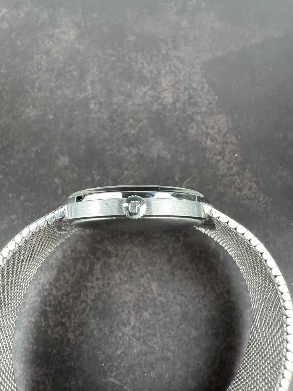 Side view of Girard-Perregaux opal dial watch showing steel crown and curved case profile