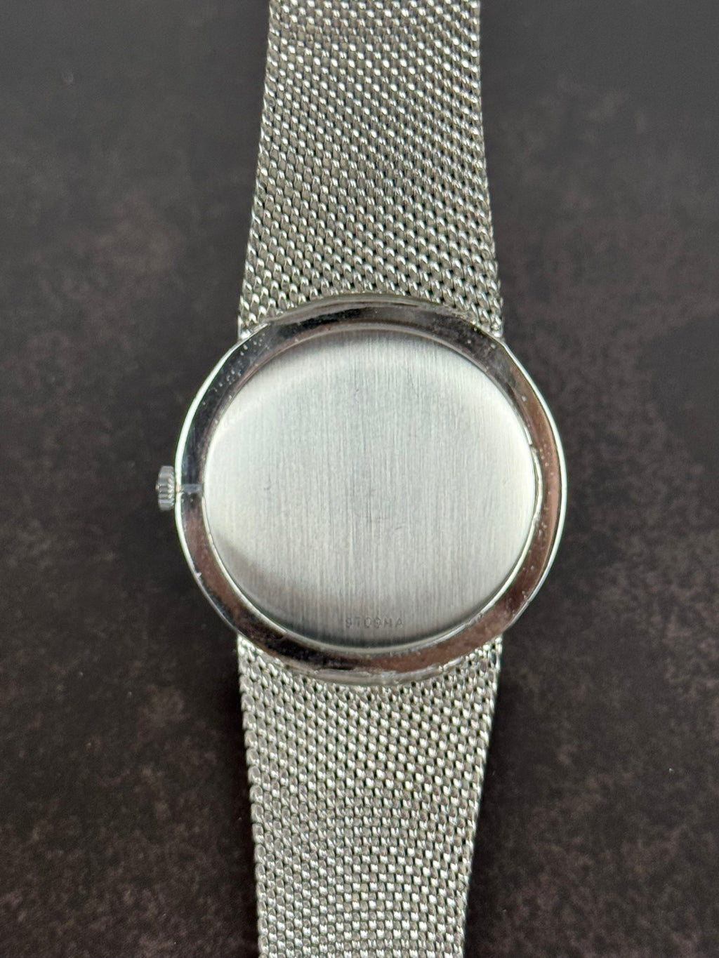 Case back of Girard-Perregaux 1990s watch in stainless steel with integrated bracelet and manual movement