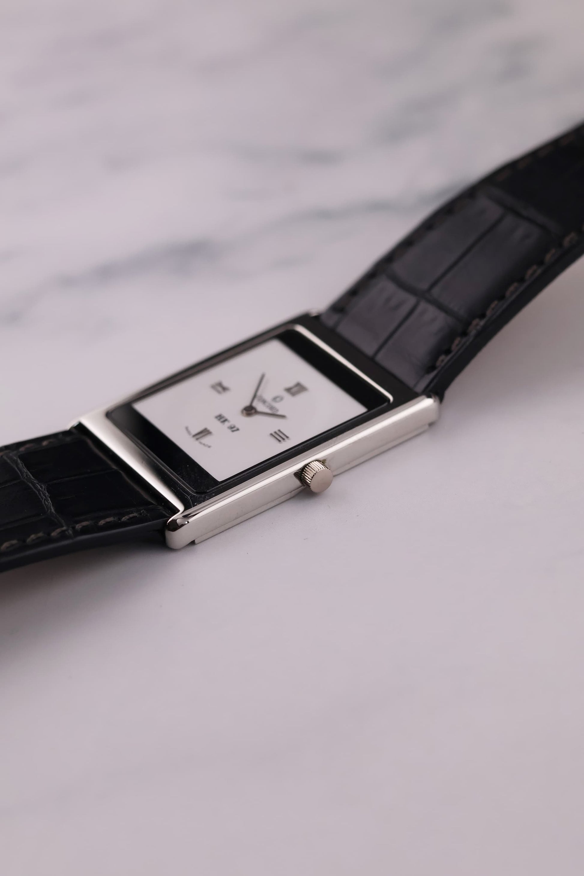Detailed shot of the platinum crown of the Concord Delirium, showing its polished finish and slim integration with the case.